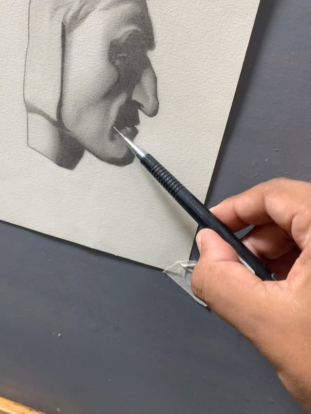 Detalhe de um retrato de perfil sendo trabalhado a lápis